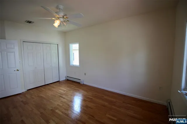 an empty room with wooden floor and window
