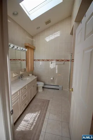 a bathroom with a granite countertop sink a mirror and a bathtub