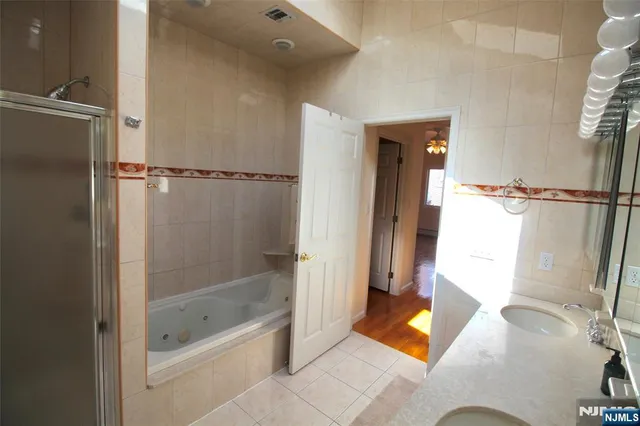 a bathroom with a tub shower and vanity