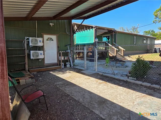 a view of a patio with table and chairs under an umbrella