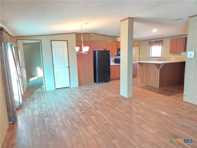 a view of a hallway with wooden floor and a bathroom