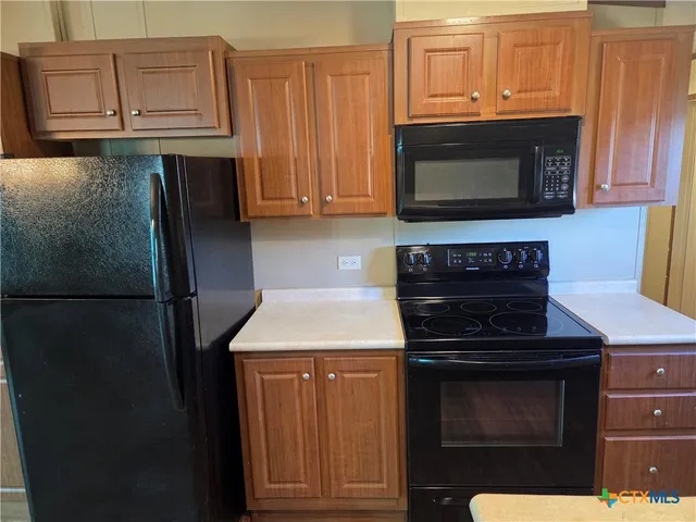 a kitchen with granite countertop stainless steel appliances and wooden cabinets