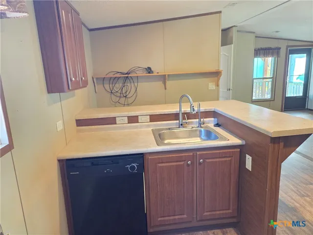 a kitchen with a sink cabinets and a window
