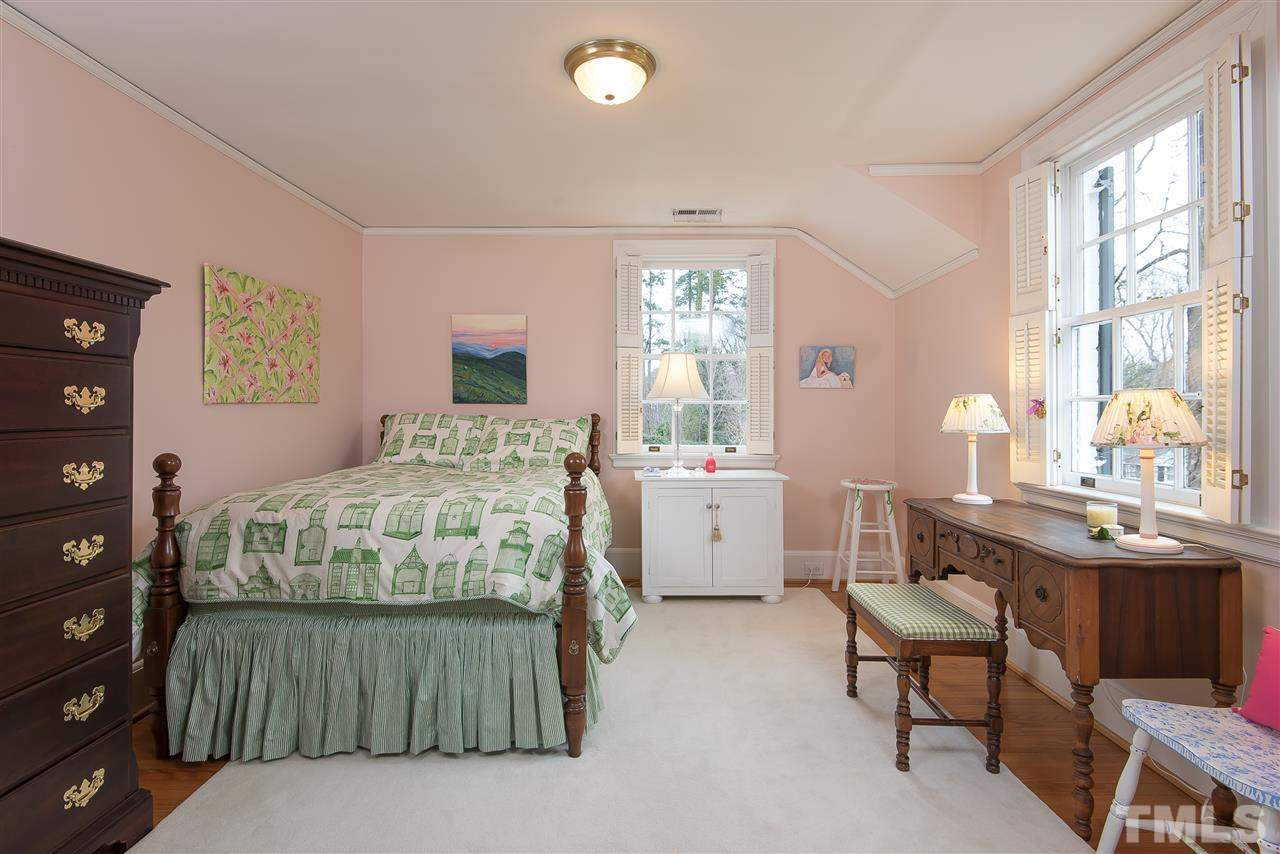 2717 Cambridge Road Raleigh, NC 27608 - Photo 16 of 21 a bedroom with a bed a table and a dresser next to a window