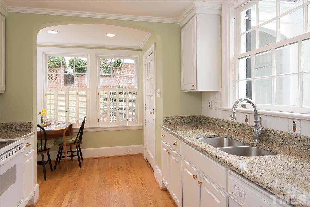 2717 Cambridge Road Raleigh, NC 27608 - Photo 5 of 21 a kitchen that has a sink a table and chairs in it