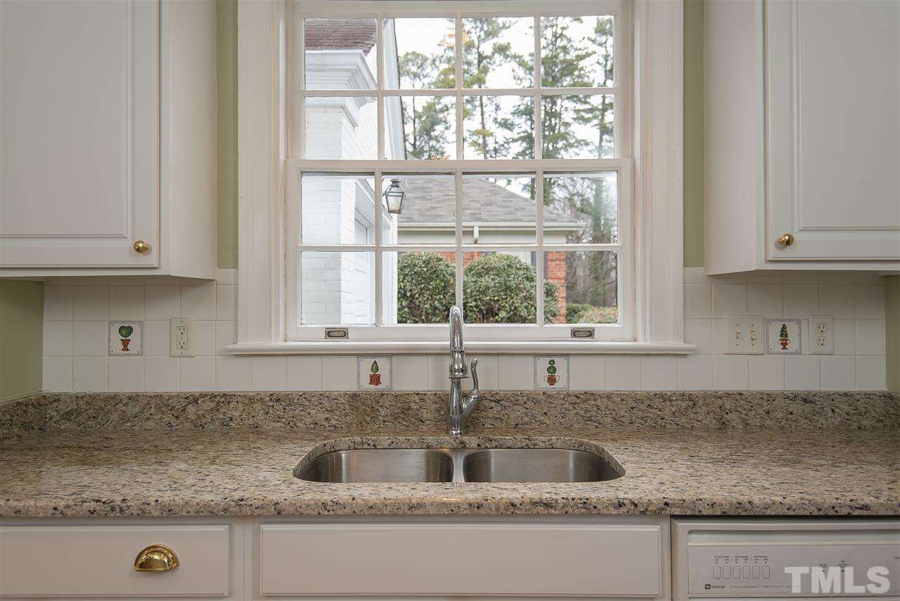 2717 Cambridge Road Raleigh, NC 27608 - Photo 7 of 21 a kitchen with granite countertop a sink window and cabinets