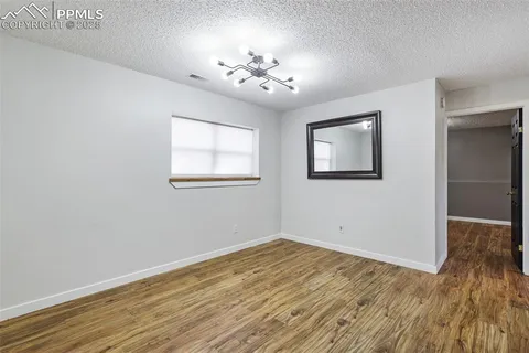 a view of wooden floor chandelier and windows in a room