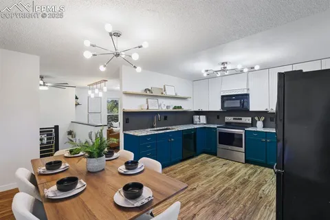 a kitchen with sink refrigerator dining table and chairs