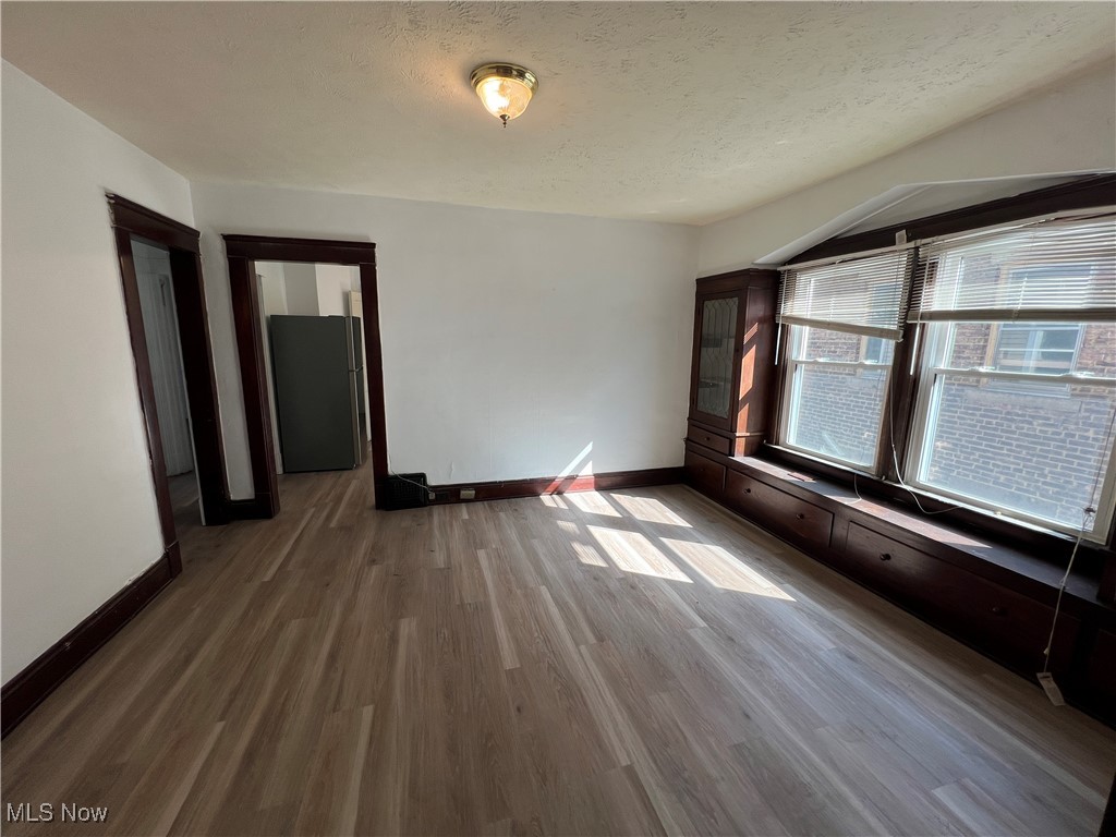491 Cleveland Road Cleveland, OH 44108 - Photo 3 of 25 Empty room with hardwood / wood-style floors and a textured ceiling