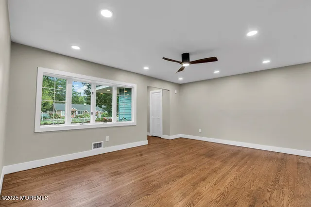 a view of a livingroom with a ceiling fan and wooden floor
