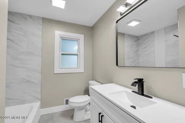 a bathroom with a sink a toilet and mirror