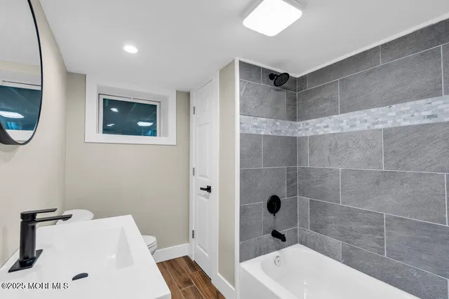 a bathroom with a sink a toilet and shower