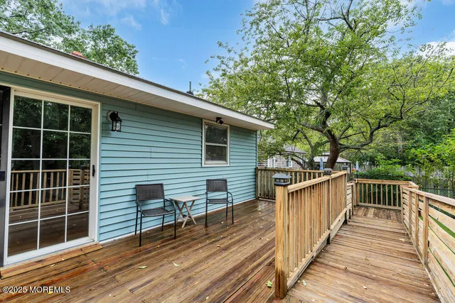 a view of a deck with wooden floor and fence next to a yard