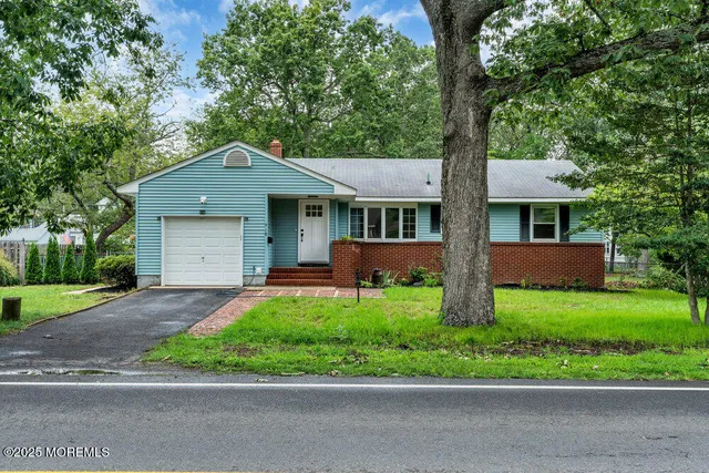 a front view of a house with a yard and trees