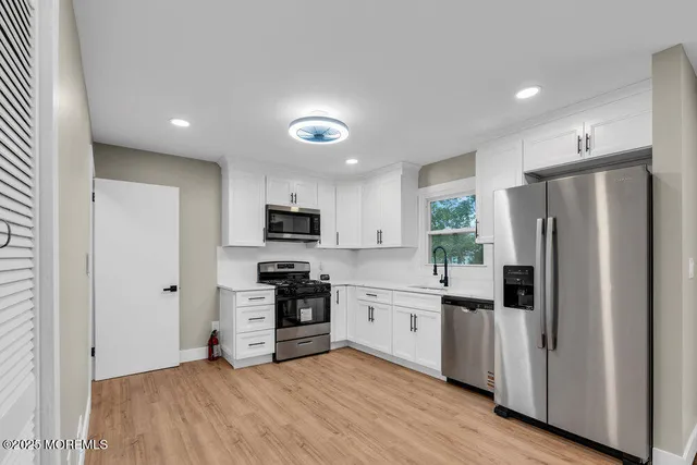 a kitchen with stainless steel appliances a refrigerator sink and stove