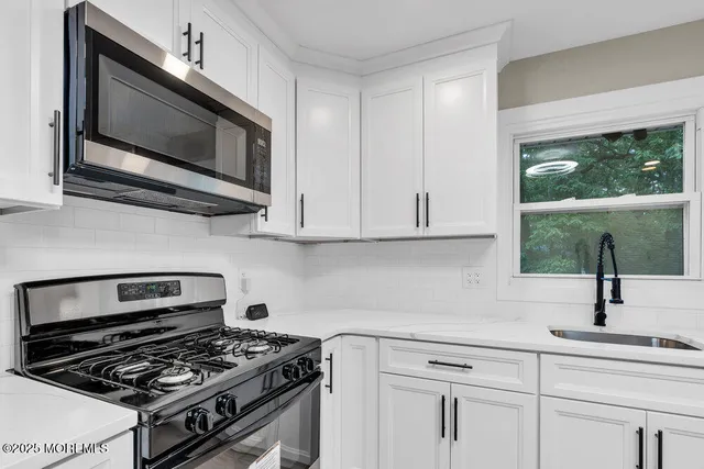 a kitchen with stainless steel appliances a stove a microwave and sink