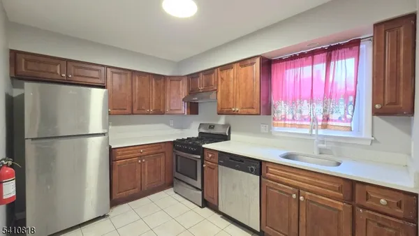 a kitchen with a refrigerator a sink and cabinets