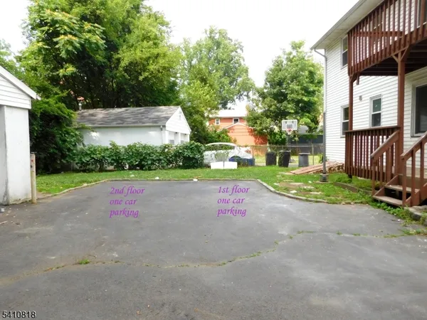 a view of small yard in front of house with large trees