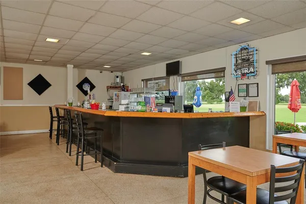 a dining hall with furniture and wooden floor