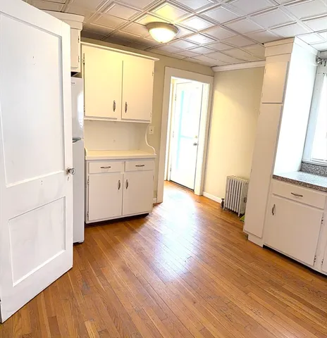 a view of a kitchen with wooden floor and electronic appliances
