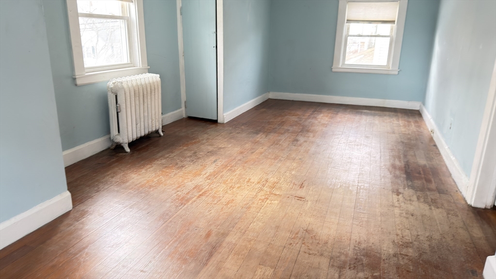 930 Sea Street Quincy, MA 02169 - Photo 18 of 29 an empty room with wooden floor and windows