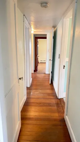 a view of a hallway with wooden floor and staircase