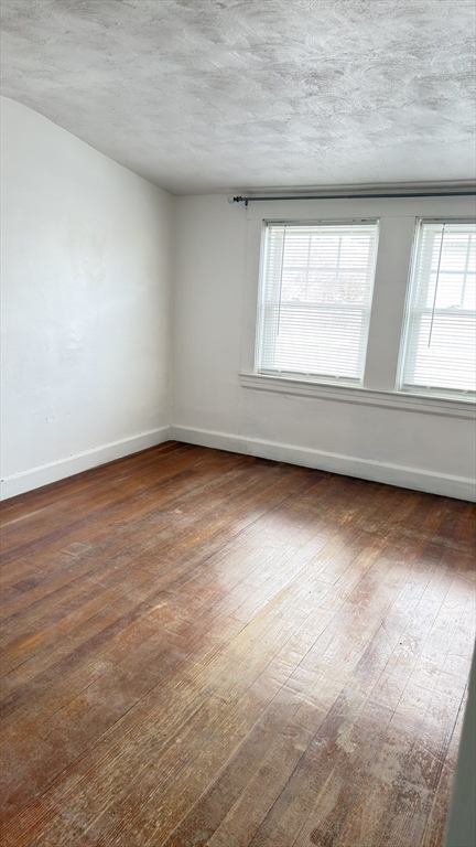 930 Sea Street Quincy, MA 02169 - Photo 24 of 29 an empty room with wooden floor and windows