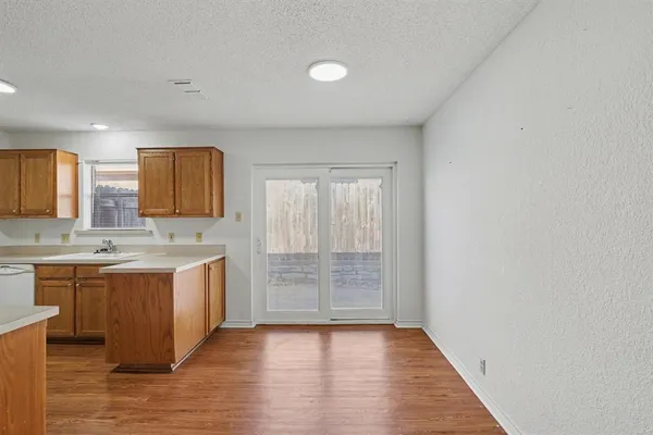 a view of a kitchen with wooden floor and electronic appliances