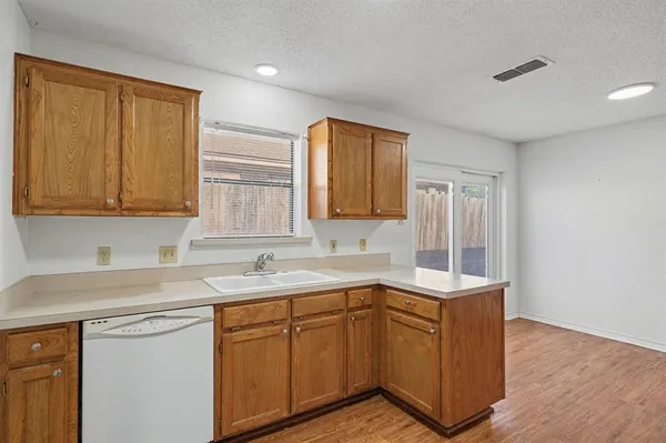a kitchen with a sink cabinets and wooden floor