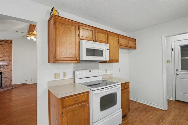 a kitchen with stainless steel appliances granite countertop a stove a microwave and a white cabinets