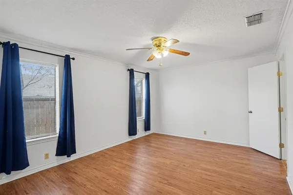 a view of a room with wooden floor and ceiling fan