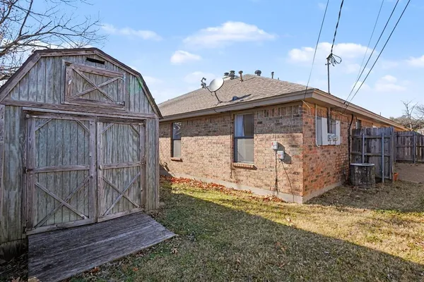 a view of a house with a small yard and wooden fence