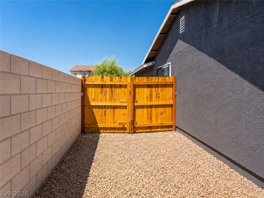 2870 South Sandhill Road Las Vegas, NV 89121 - Photo 13 of 64 Secure yard access with a sturdy wood fence, alongside a durable concrete block wall.