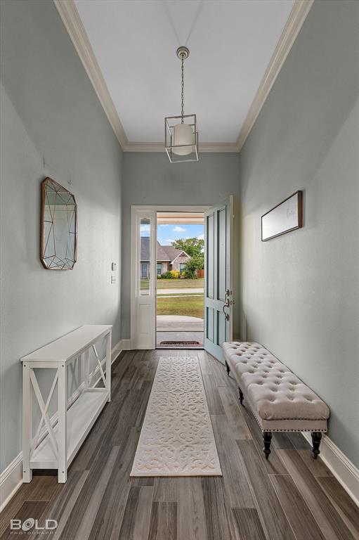 143 Oak Alley Road Stonewall, LA 71078 - Photo 7 of 38 Recessed entryway featuring wood-finish flooring, crown molding, and a distinctive geometric pendant light fixture