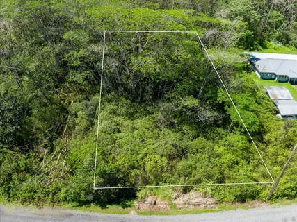 an aerial view of residential houses with outdoor space and trees