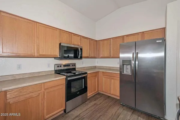 a kitchen with cabinets stainless steel appliances and wooden floor