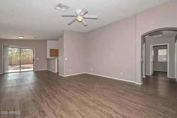 a view of an empty room with window and wooden floor
