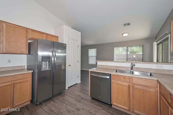 a kitchen with kitchen island granite countertop a sink and refrigerator