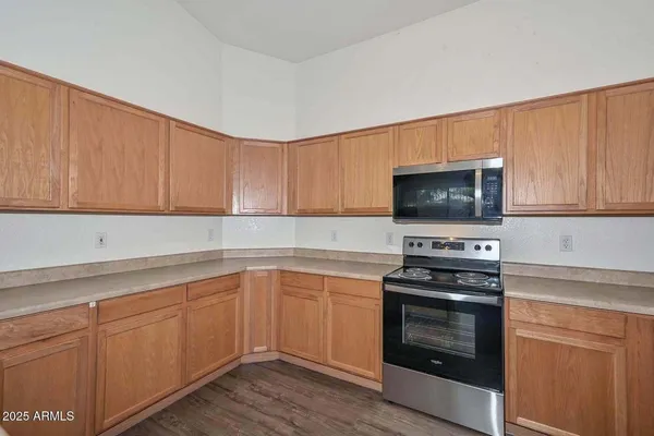 a kitchen with granite countertop a stove top oven microwave and cabinets