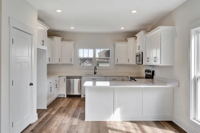 a kitchen with white cabinets stainless steel appliances and sink