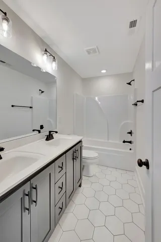 a view of an empty room with a chandelier fan