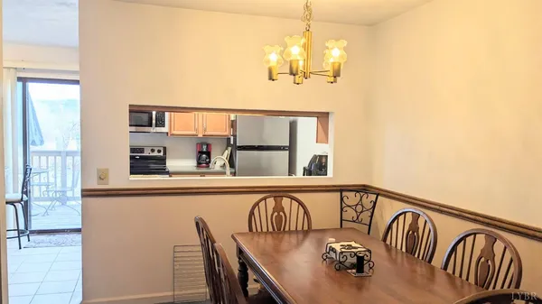 a view of a dining room with furniture a chandelier and wooden floor