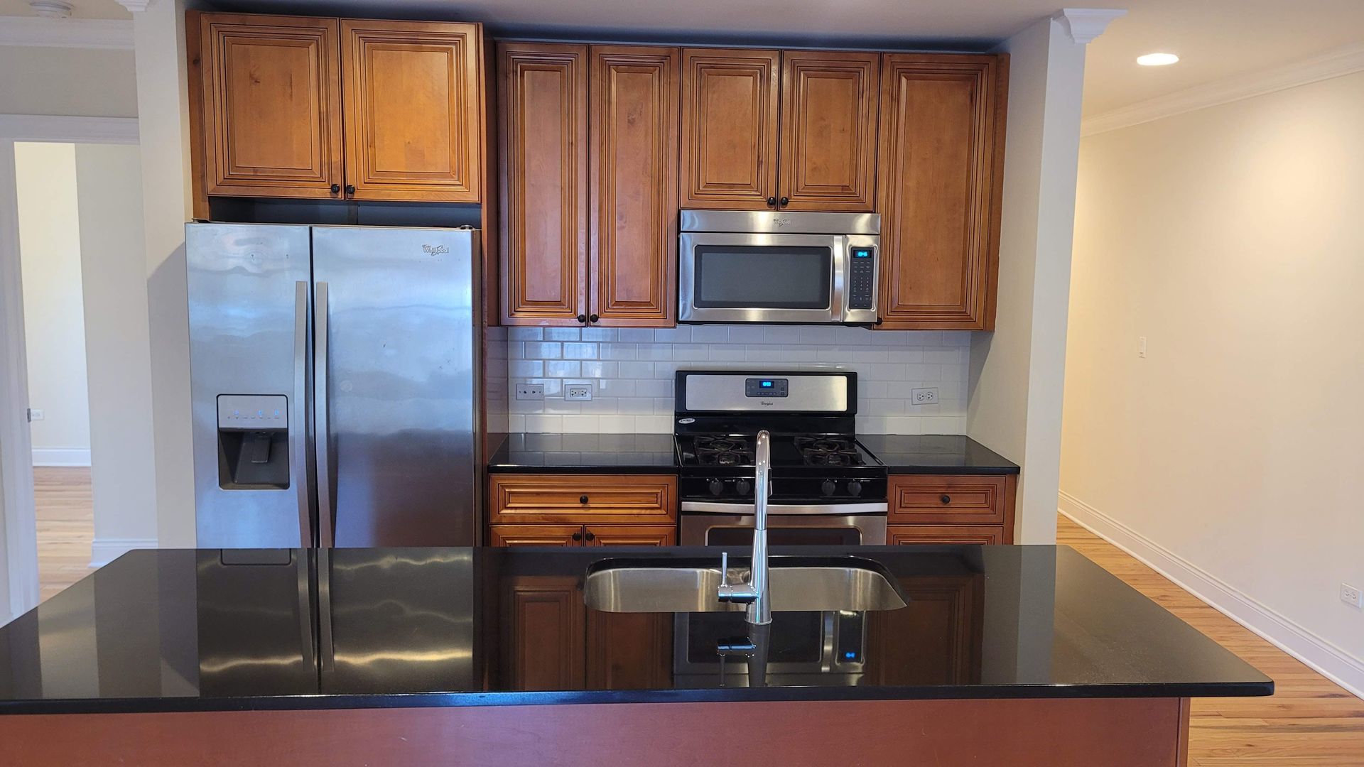 4520 North Beacon Street, Unit 401 Chicago, IL 60640 - Photo 4 of 11 a kitchen with granite countertop a refrigerator and a stove top oven