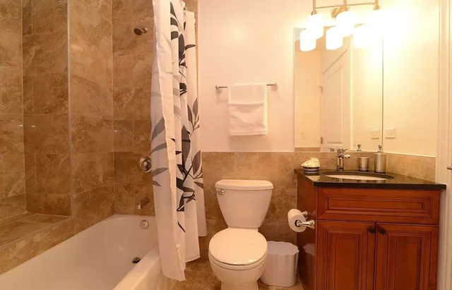 a bathroom with a granite countertop toilet a sink and a bathtub