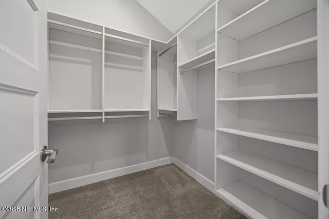 a bedroom with a bed and a flat tv screen on dresser