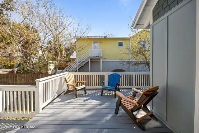 a view of a house with a wooden deck and a yard