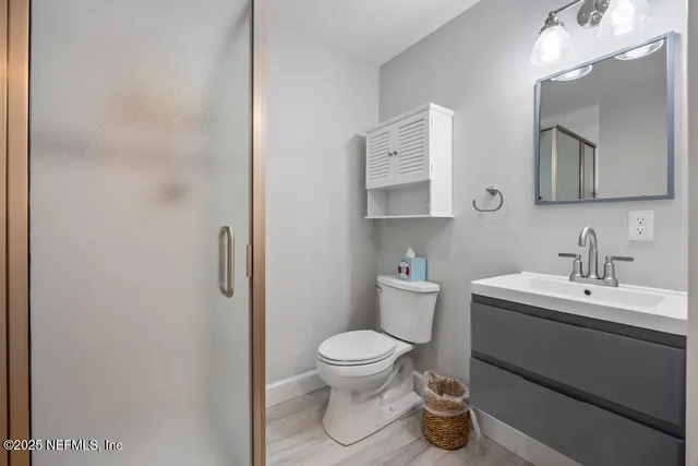 a view of a backyard with large trees and wooden fence