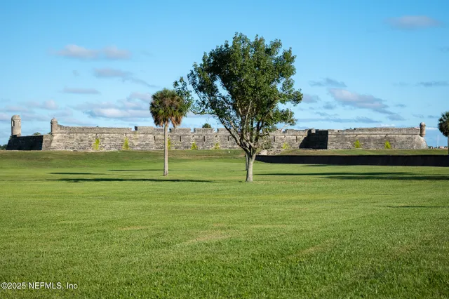 a kitchen with stainless steel appliances granite countertop a sink a stove white cabinets with wooden floor