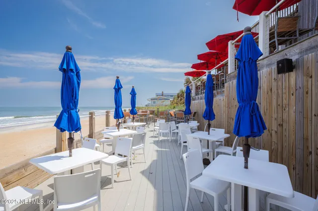 a kitchen with stainless steel appliances a stove top oven a sink a refrigerator white cabinets and wooden floor