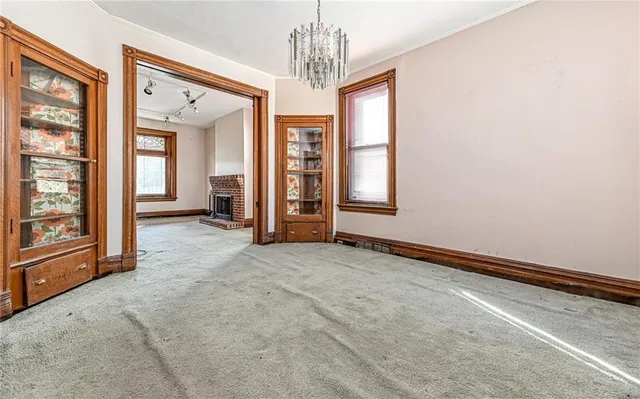 en empty room with windows and chandelier